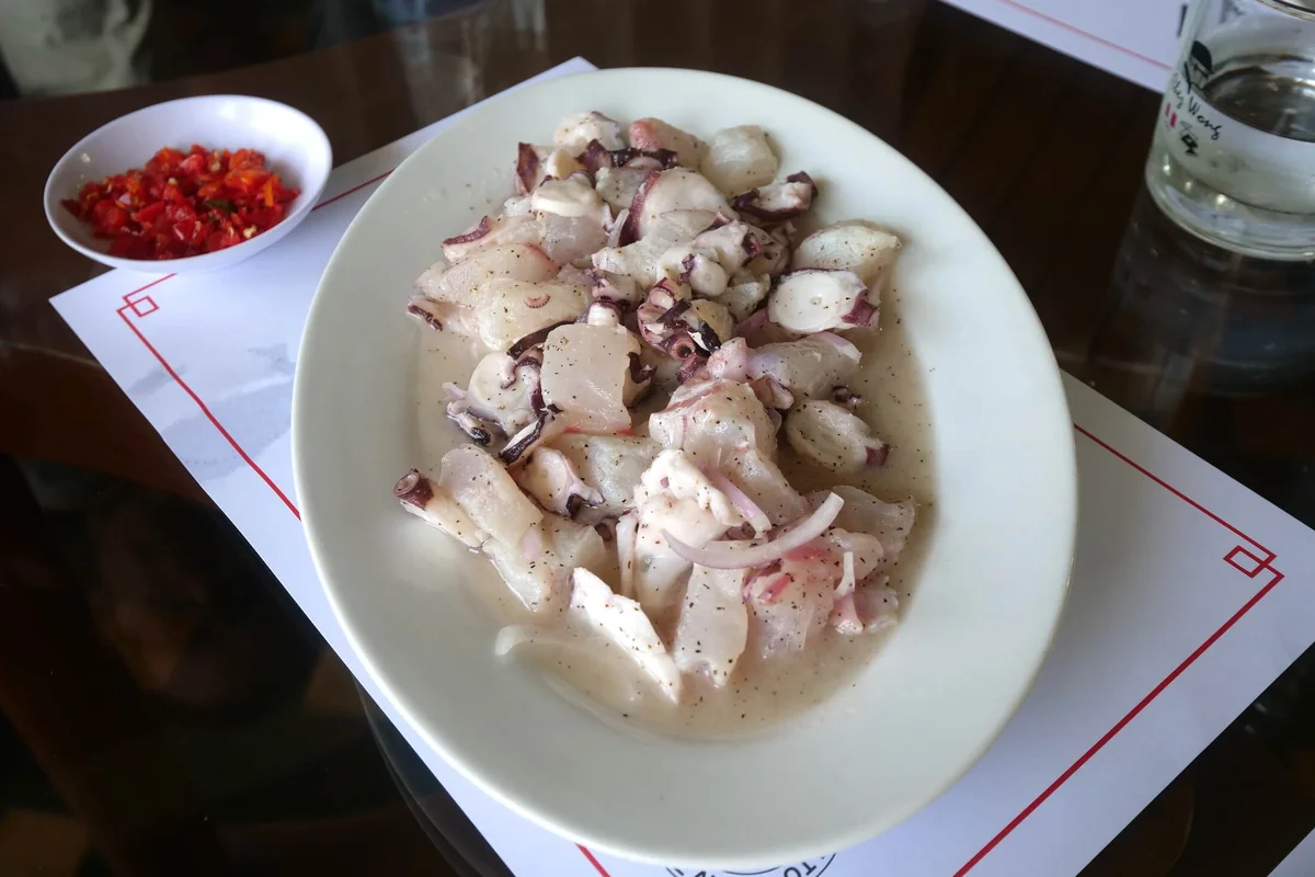 Plated ceviche with octopus on dark wooden table