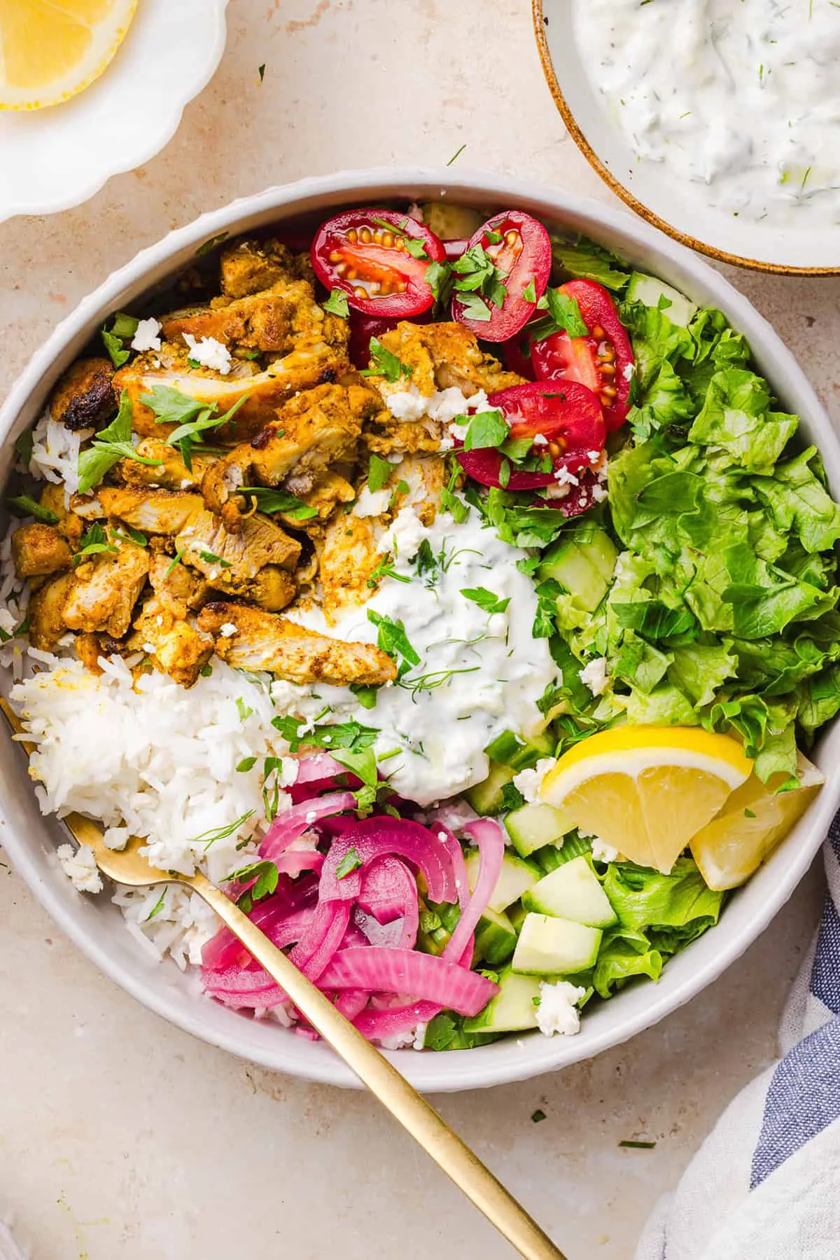 Overhead view of shawarma bowl with rice, chicken, vegetables and herbs