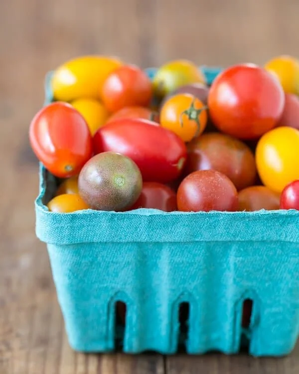 Punnet of colorful cherry tomatoes in red, yellow, orange, and purple