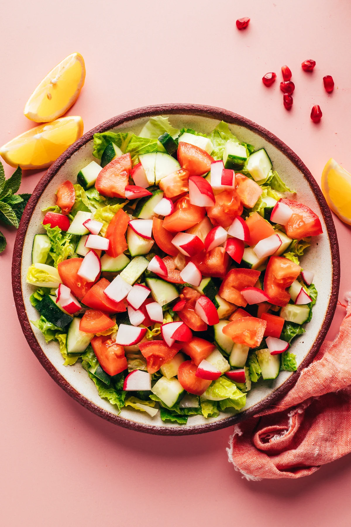 Chopped cucumber, tomato, and radish ready for the bowl