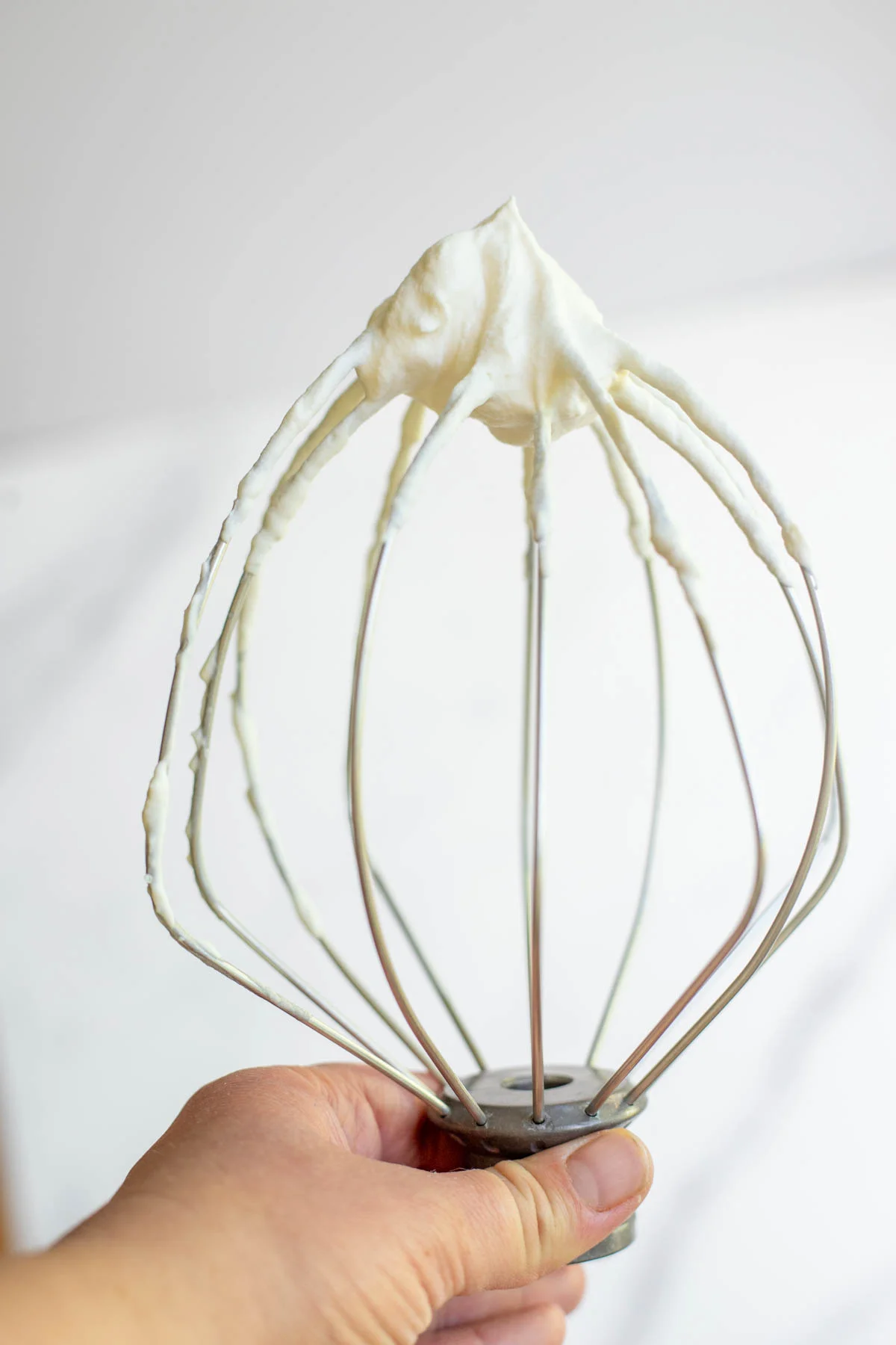 Cream whipped to soft peaks in a steel mixing bowl