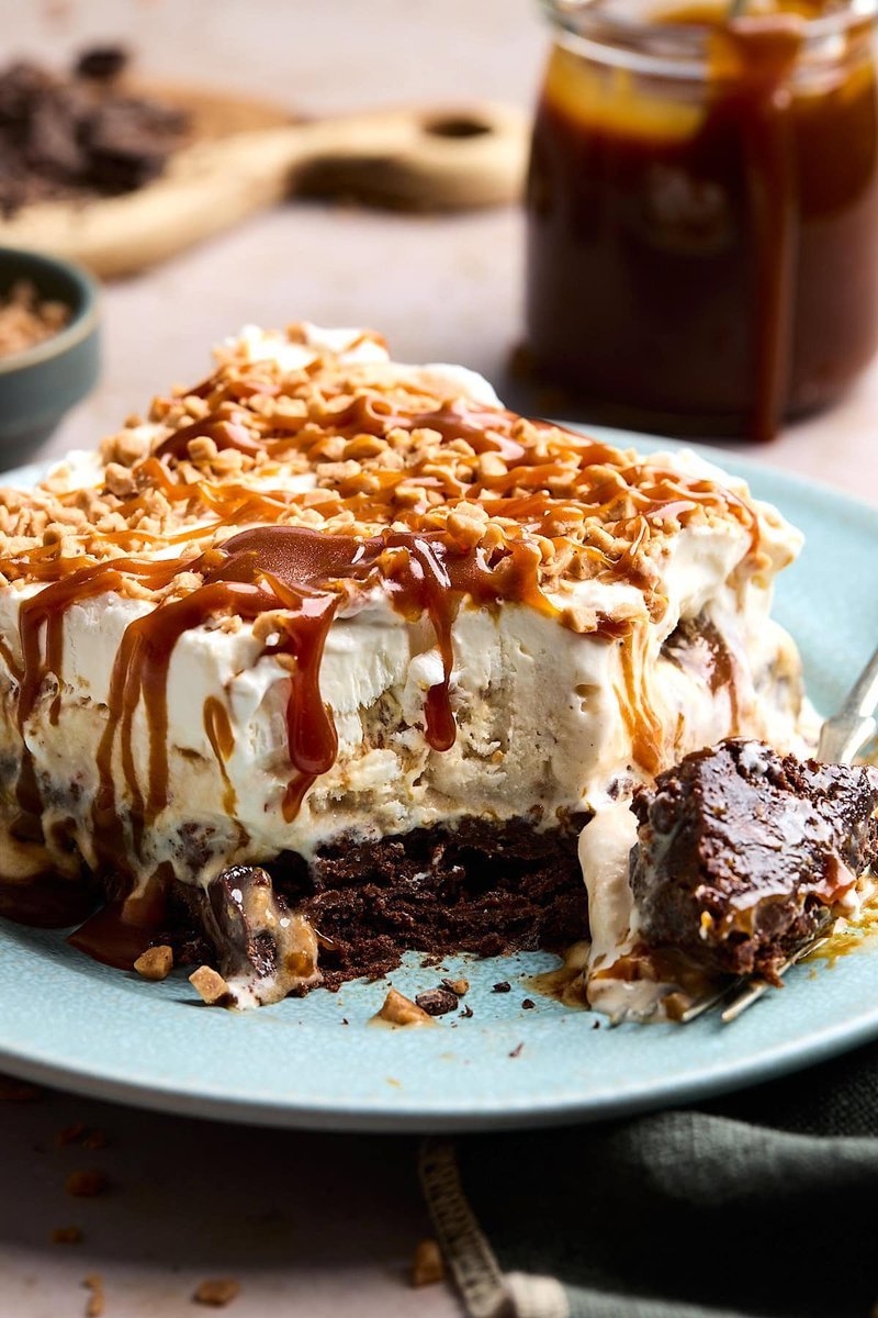 Brownie ice cream cake slice with whipped cream and caramel drizzle
