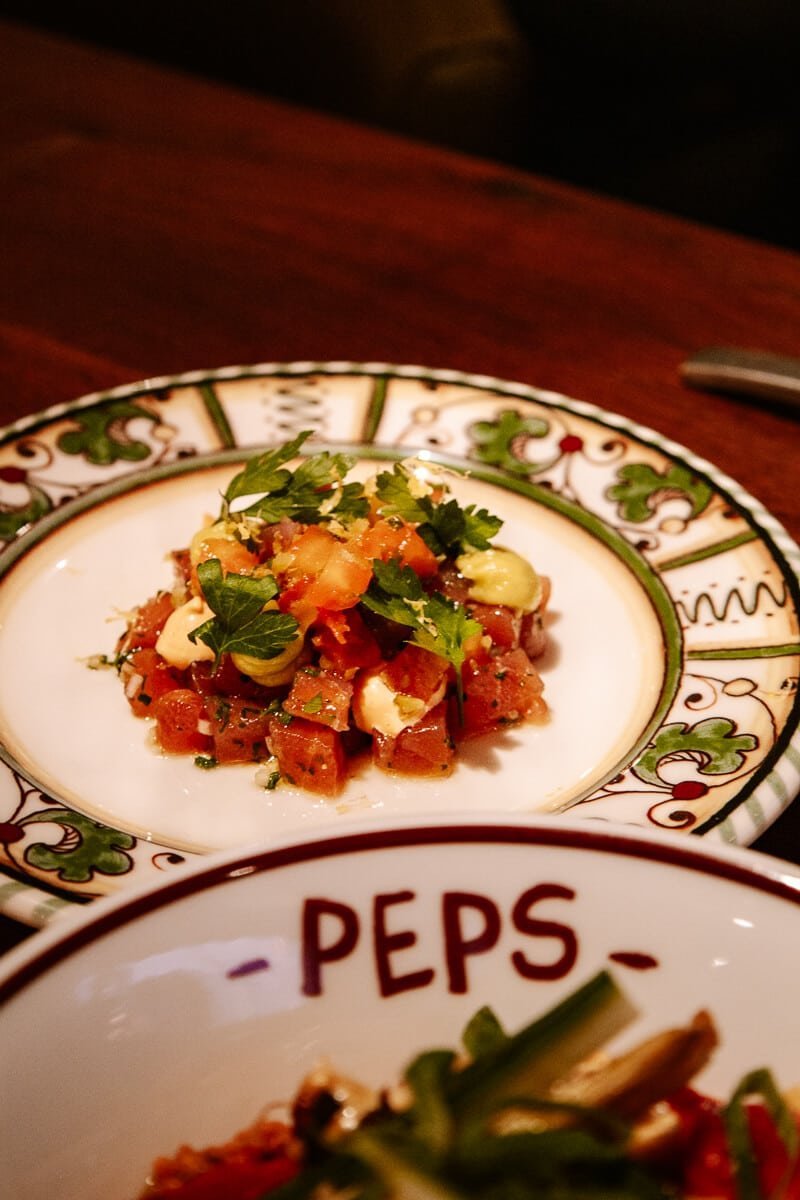 Plated Spanish dishes from Peps on dark wooden table
