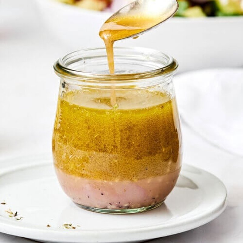 Raspberry vinaigrette with fresh raspberries garnish in a small glass bottle