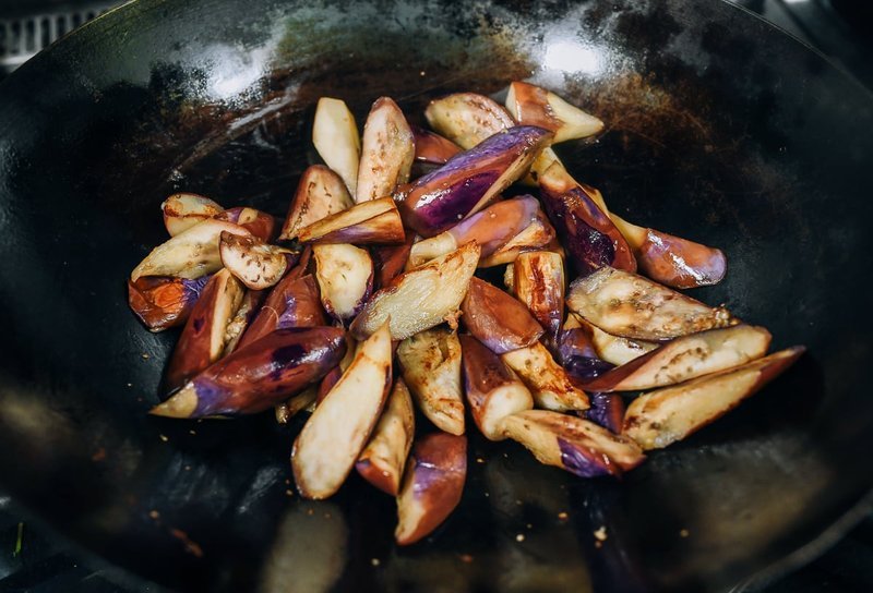 Eggplant wedges searing in a hot wok