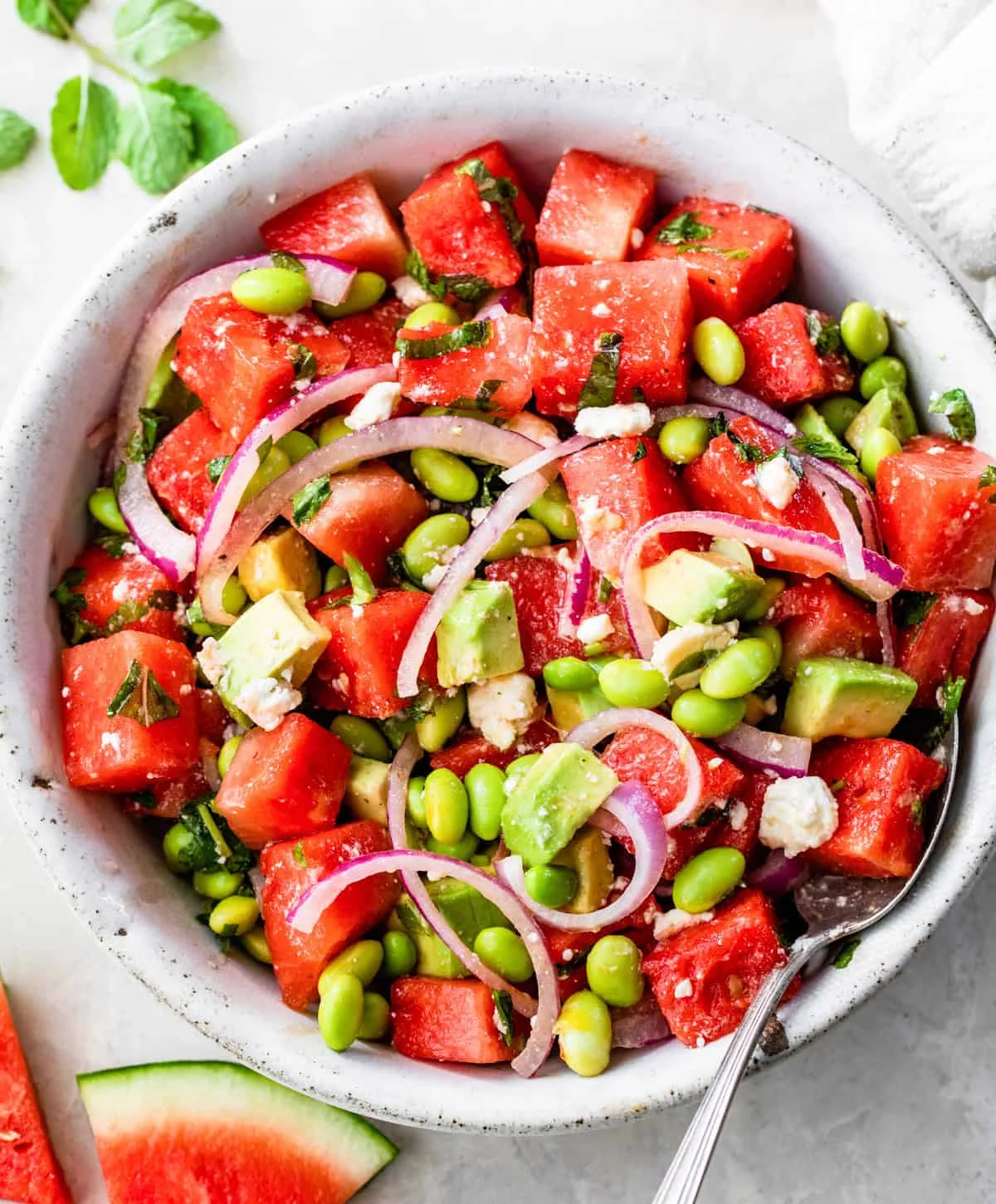 Bright watermelon salad with feta and herbs in a glass bowl