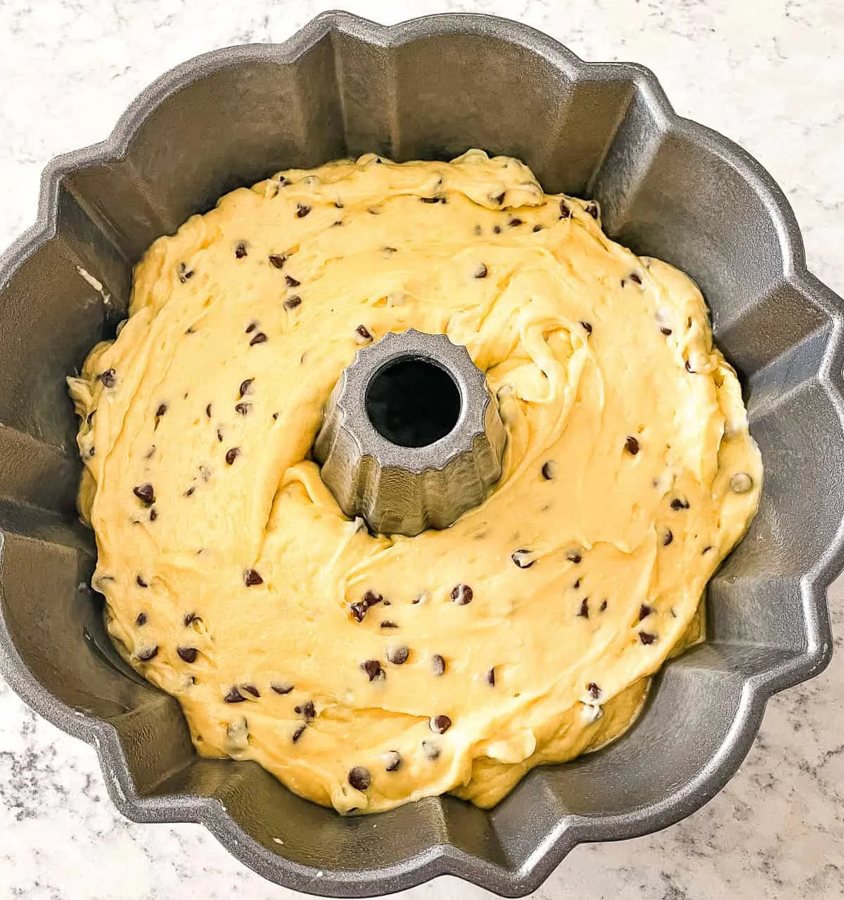 Chocolate chip bundt cake baked and cooled, golden with melted chocolate chips visible