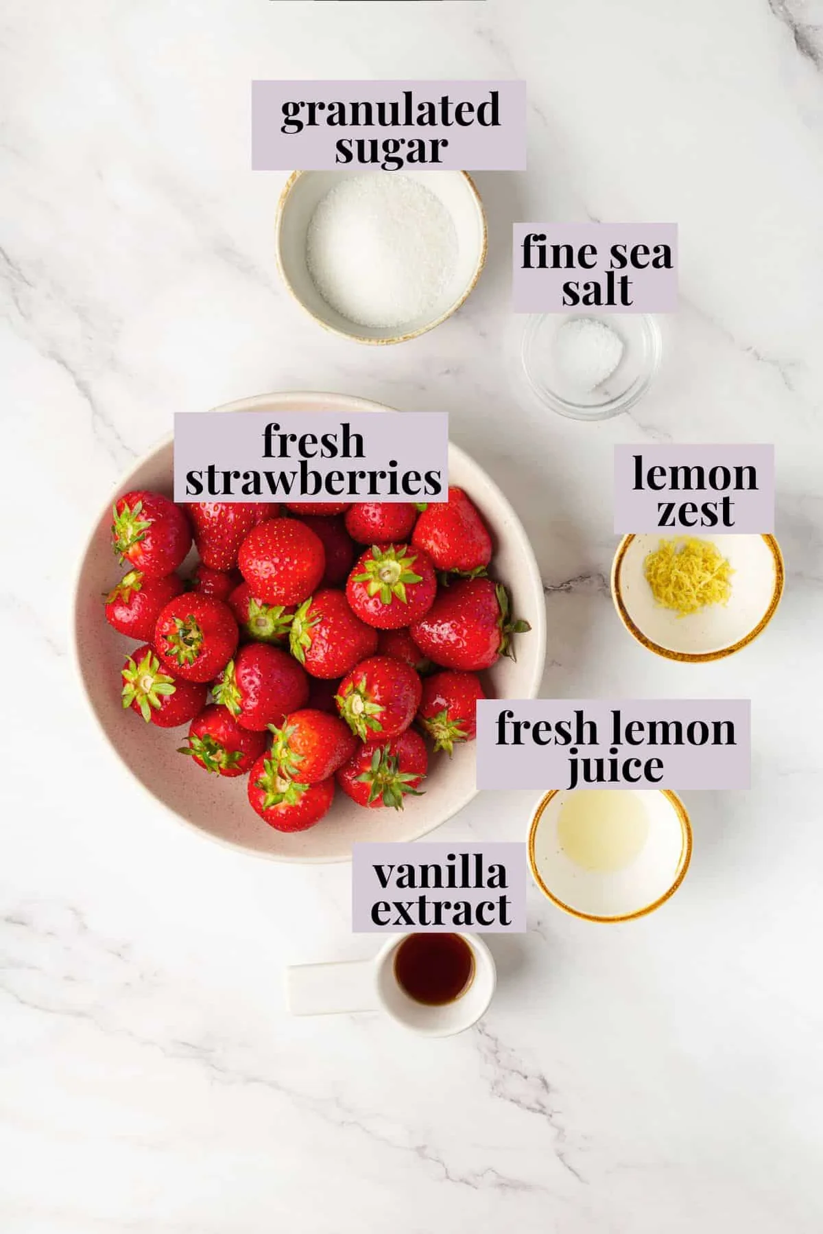 Five macerated strawberry ingredients arranged on white marble