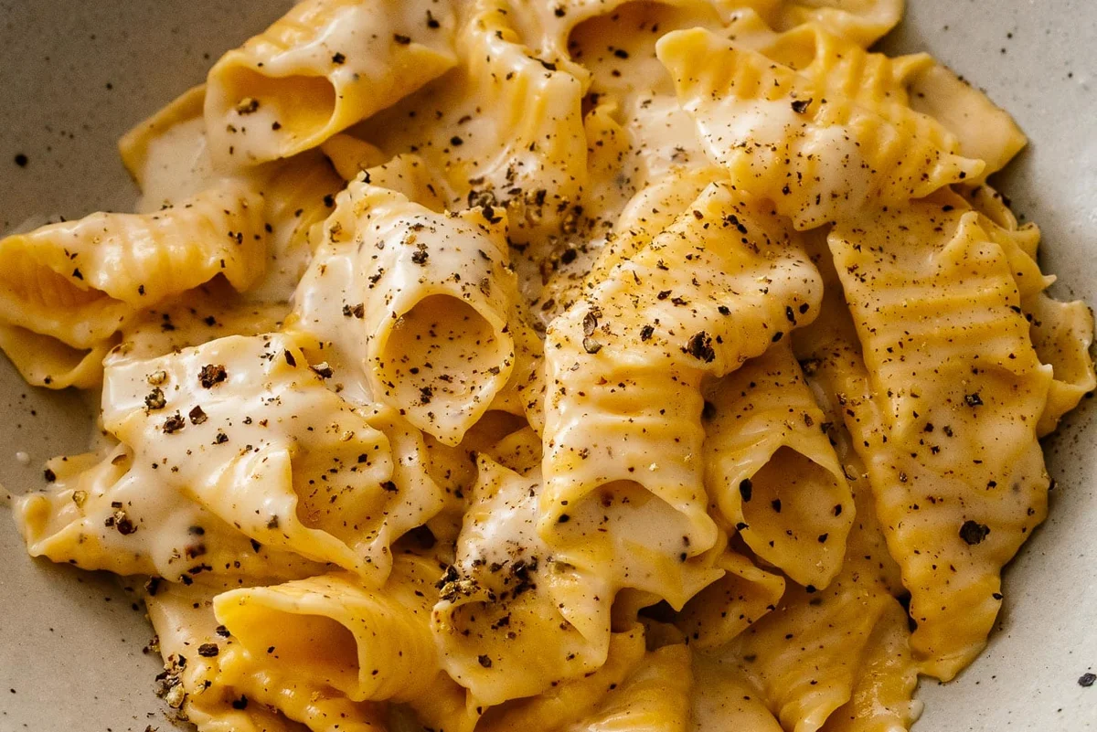Creamy pecorino pasta coated in glossy sauce with cracked black pepper