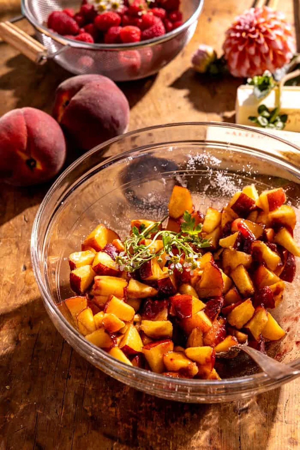 Frosted peach cake topped with peach slices and raspberries