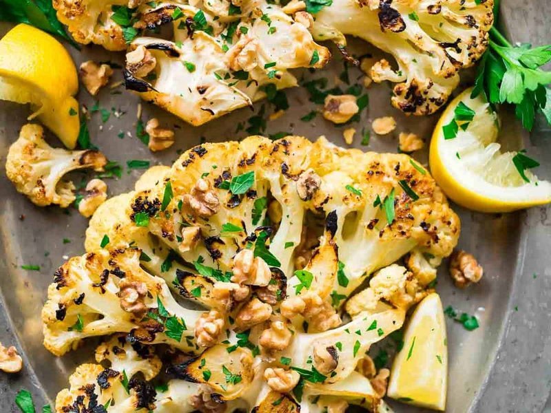 Thick sliced grilled cauliflower steaks caramelized on the grill