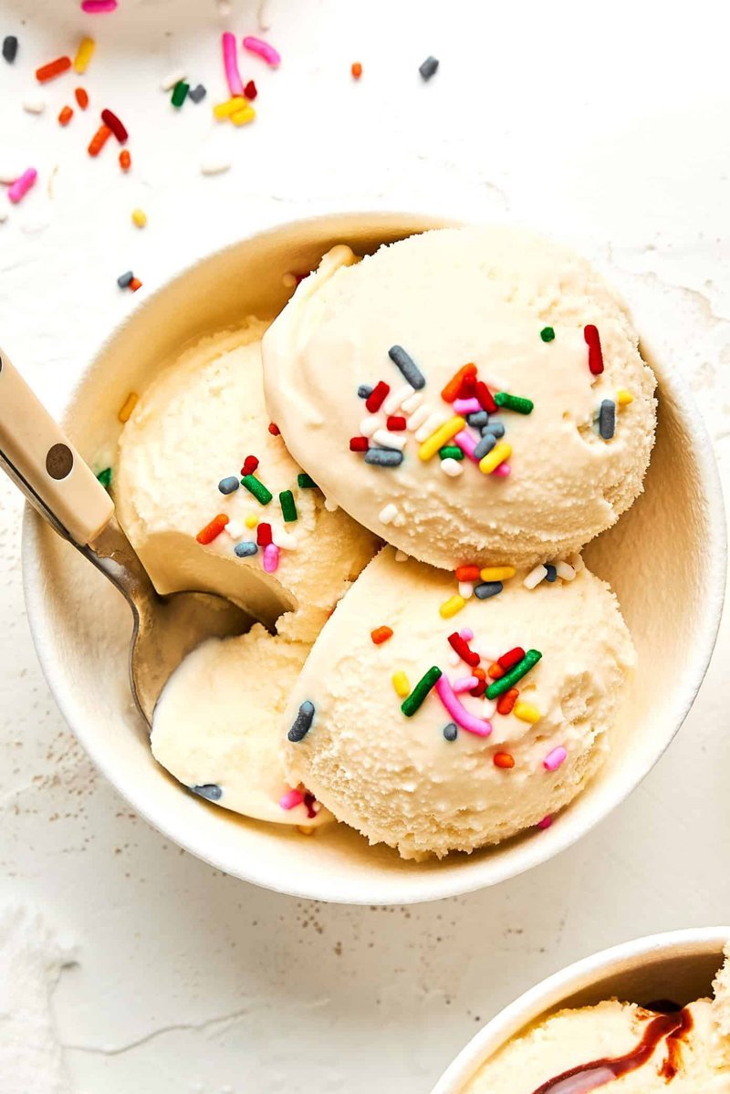 Finished tub of homemade vanilla ice cream with a scoop