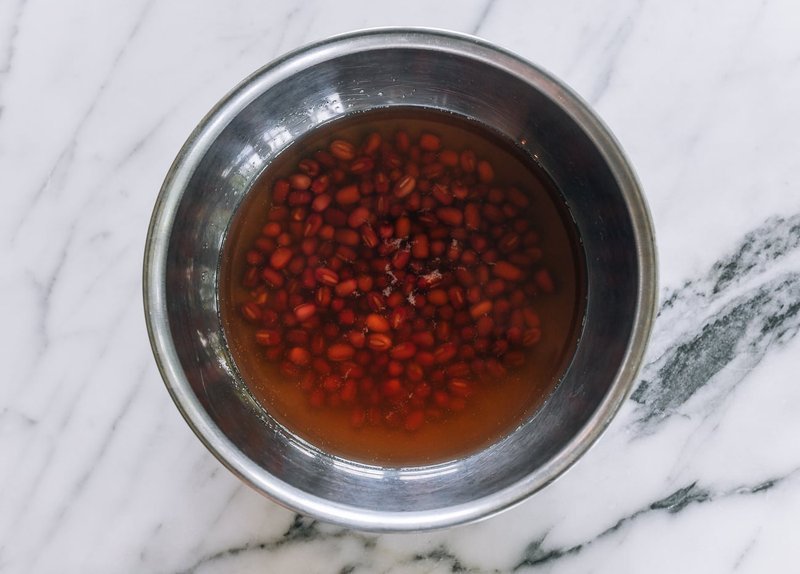Dried adzuki red beans soaking in a metal bowl