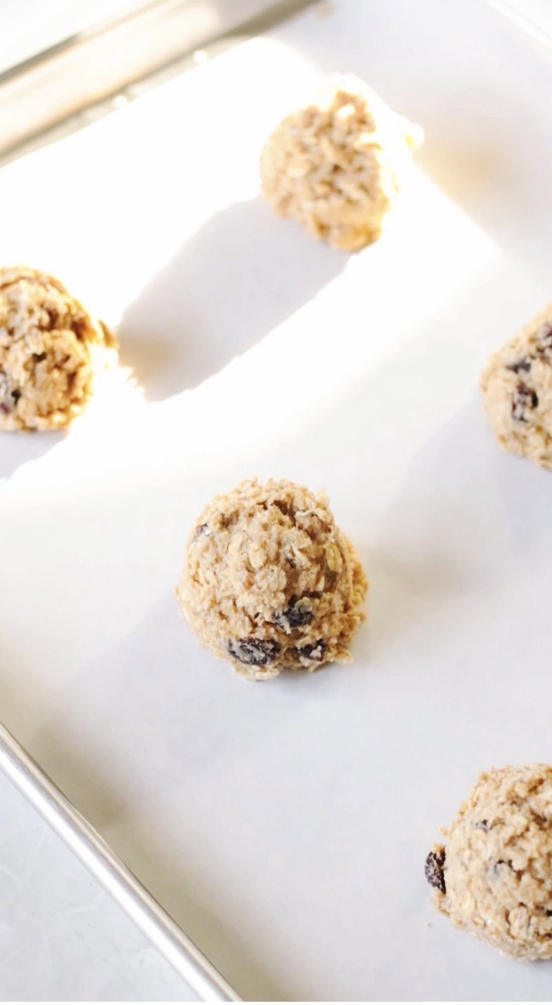 Cookie dough scoops on a lined baking sheet