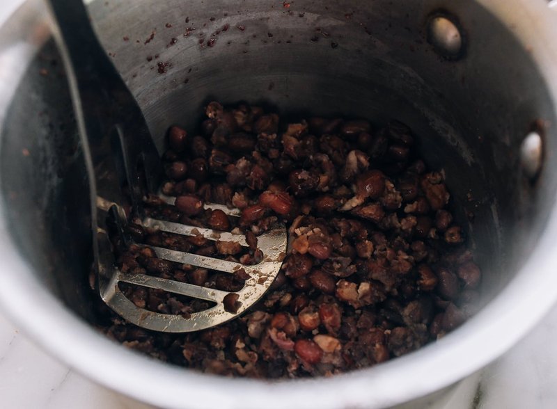 Mashed red bean paste being stirred in a pot