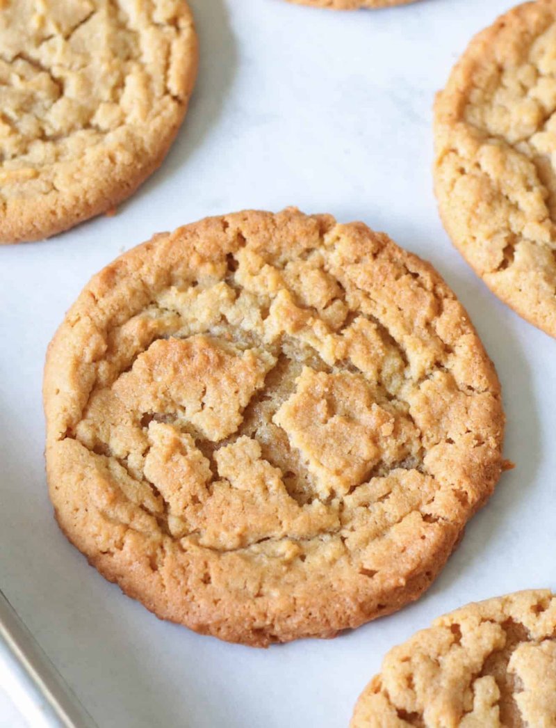 Freshly baked peanut butter cookies cooling on a baking sheet