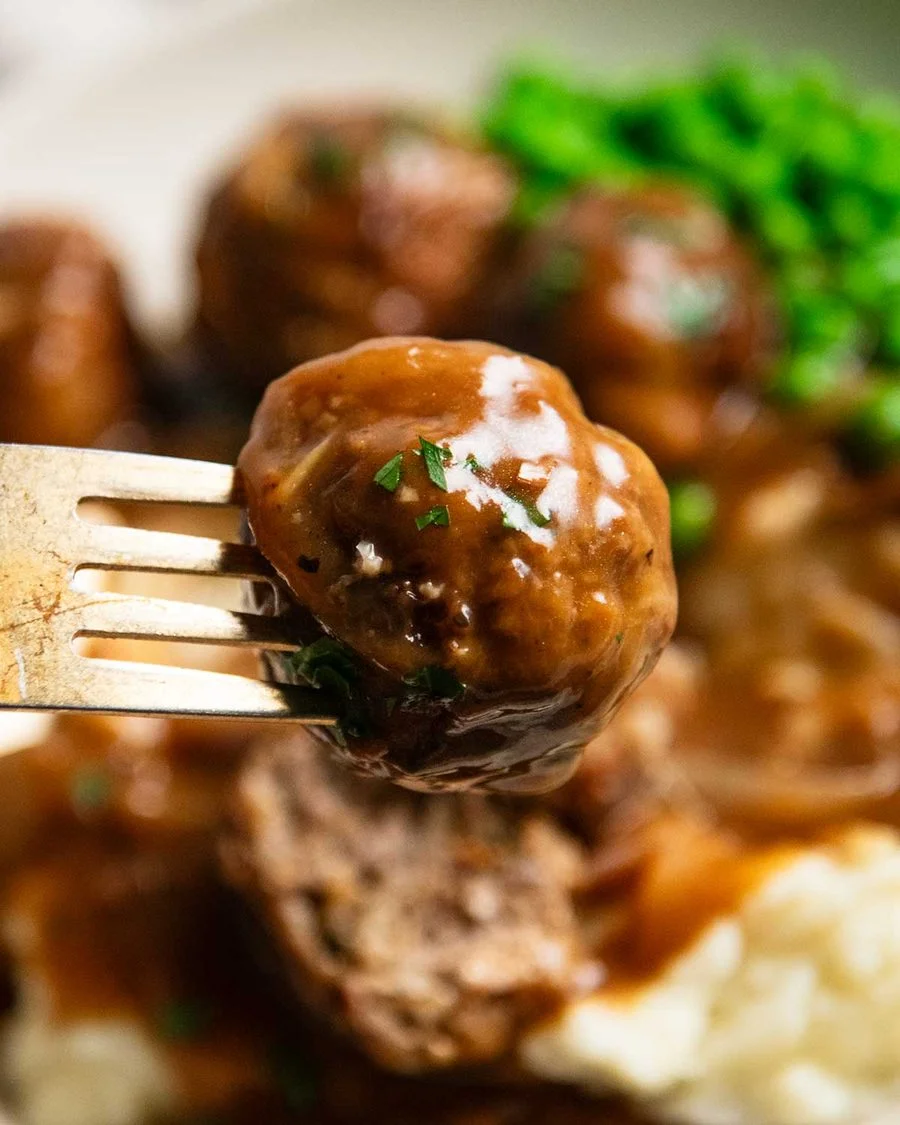 Finished meatballs simmering in thick onion gravy
