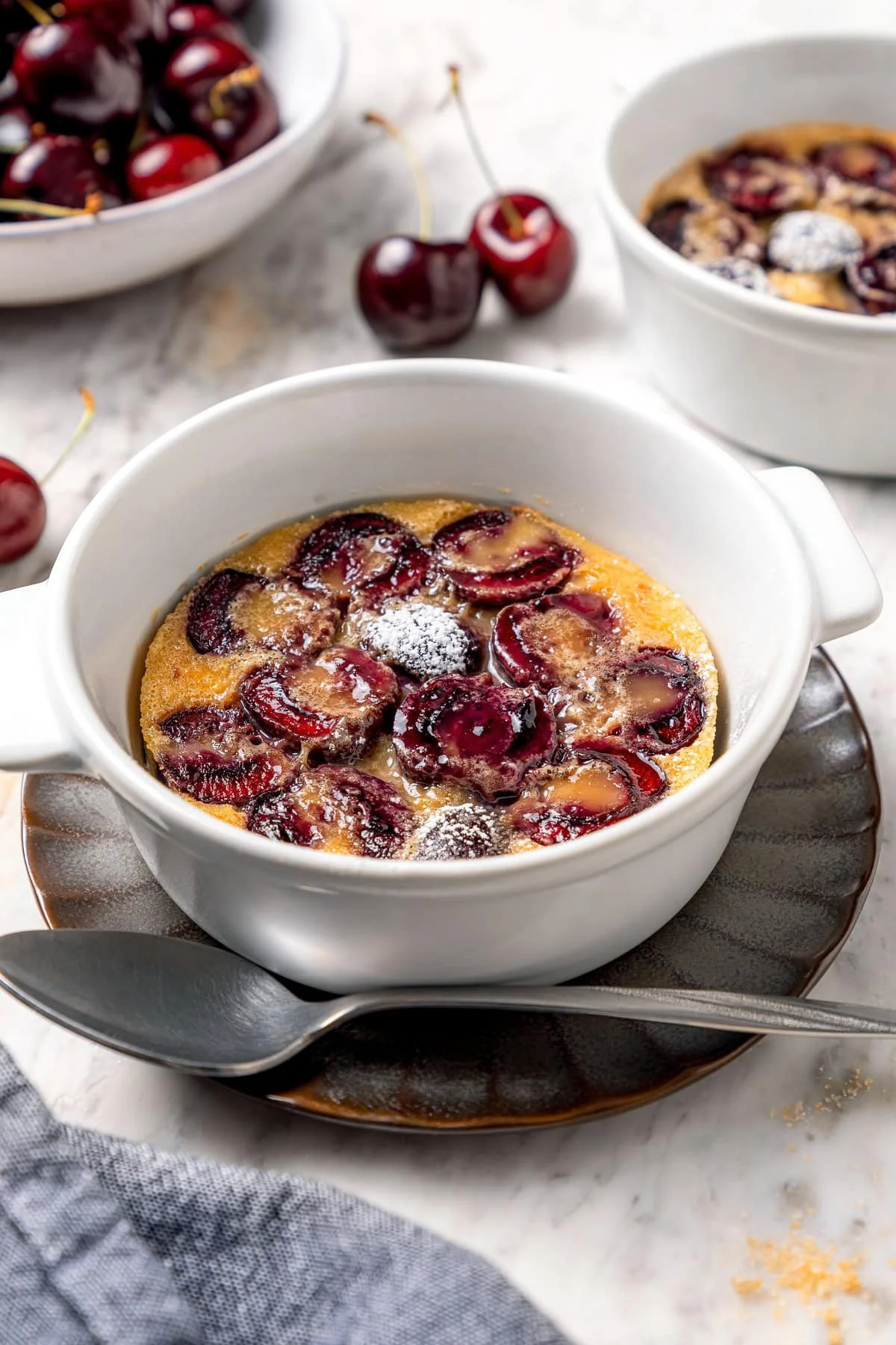 Cherry clafoutis ramekins puffed golden with fresh cherries